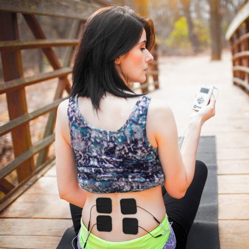 Small iReliev TENS EMS Pads shown in use on the lumbar lower back to treat muscle inflammation.