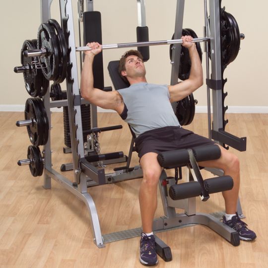 A user performing his elevated bench pressing routine with the Body-Solid Series 7 Smith Gym System