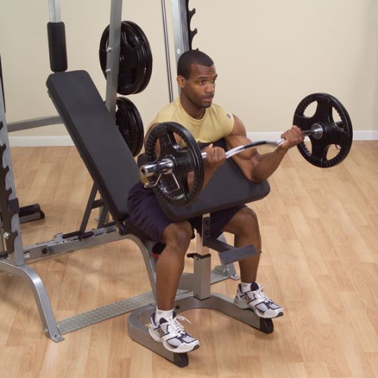 The user exercising their bicep muscles with the Body-Solid Series 7 Smith Gym System