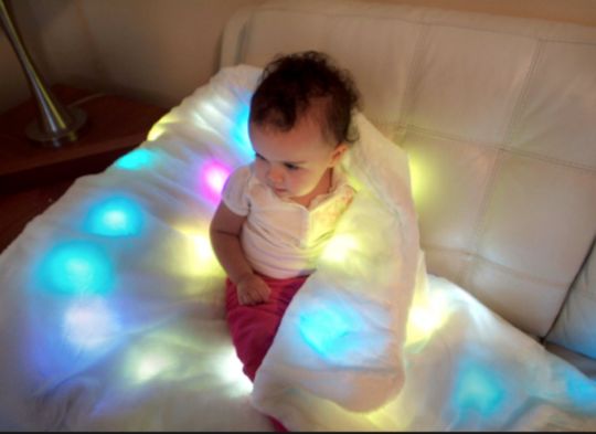 Child using the LED Multi-Sensory Light-Up Blanket 