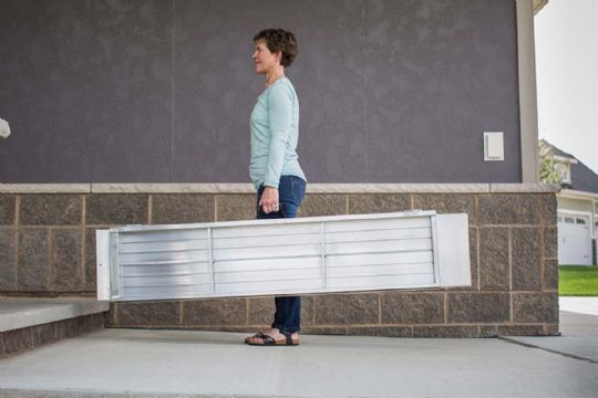 The ramp's full-length central hinge and flexible handles that allow them to be folded