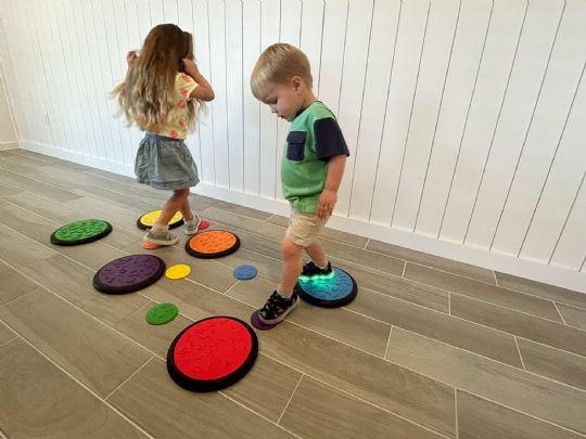 Children engaging in sensory play with colorful tactile game tiles