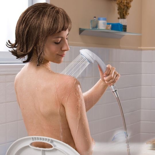 Woman using aquasense handheld shower for a comfortable, seated bathing experience