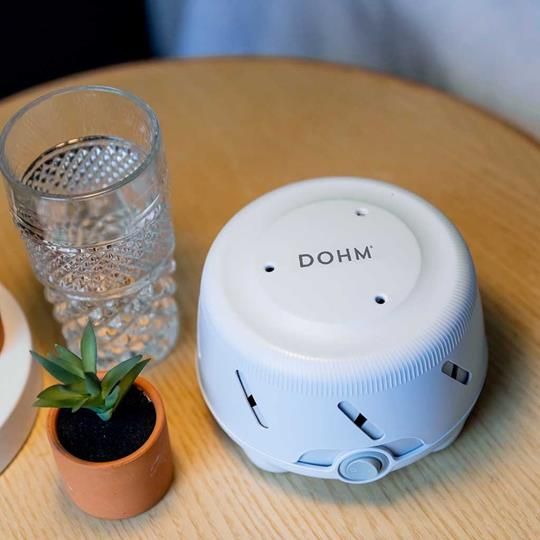 Yogasleep Dohm Uno White Noise Machine on a bedside table, perfect for creating a peaceful sleep environment