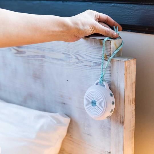 Yogasleep Rohm easily hangs on a bedpost with included lanyard