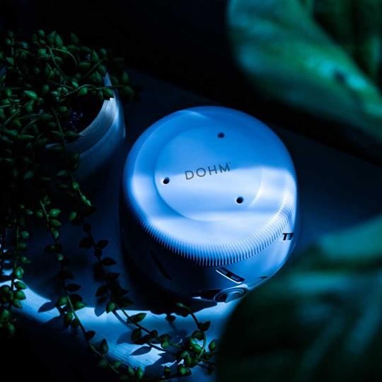 Yogasleep Dohm Uno White Noise Machine in a calming nighttime setting