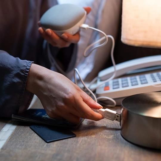 Charging the Yogasleep Travelcube white noise machine with a USB cable for reliable use