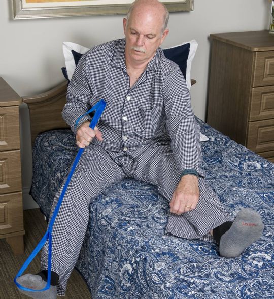 Man using a leg lifter to assist with leg positioning in bed